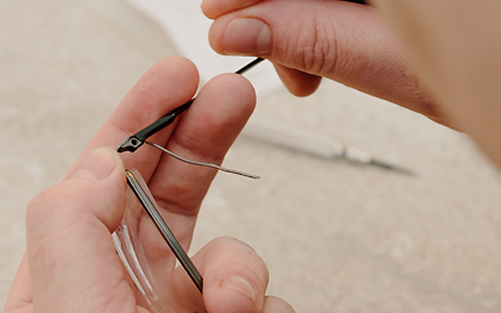 Opticien remplaçant la branche d'une paire de lunettes en atelier