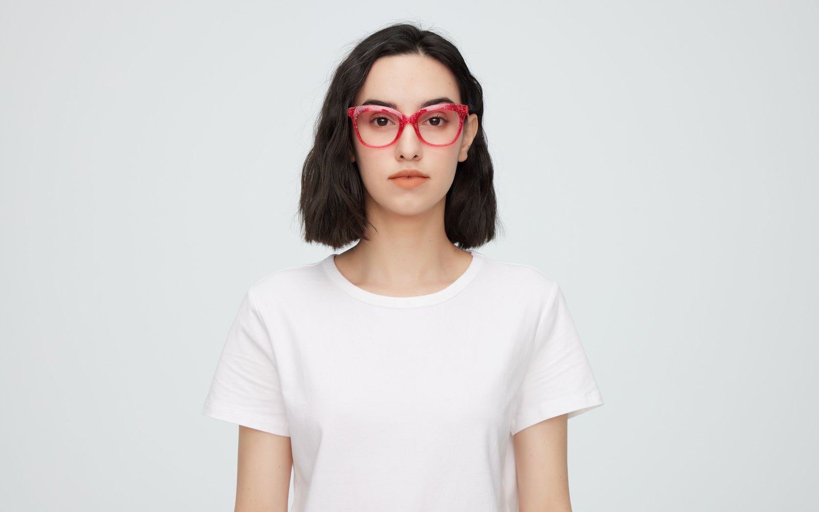 Femme portant des lunettes de vue à monture rouge pailletée